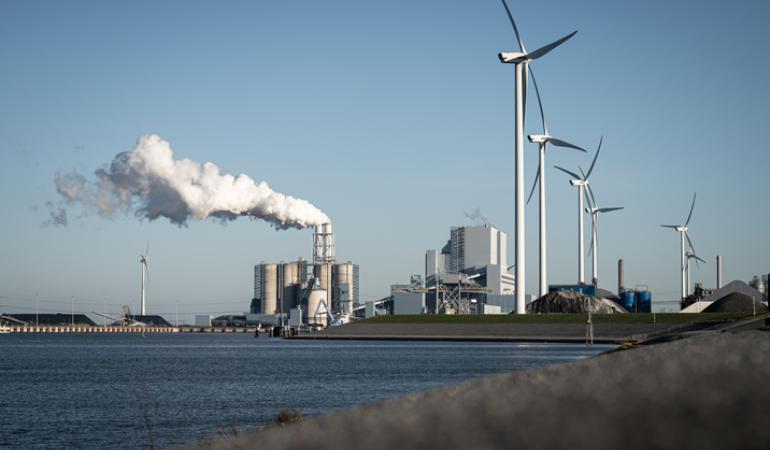 Windmolens en industrieel complex aan het water